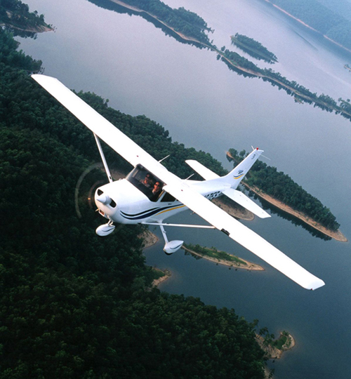 Cessna 172 in flight over lake